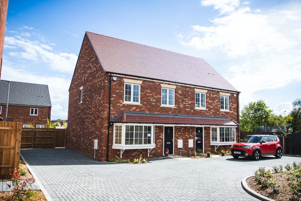 Photograph of semi-detached houses with car in driveway