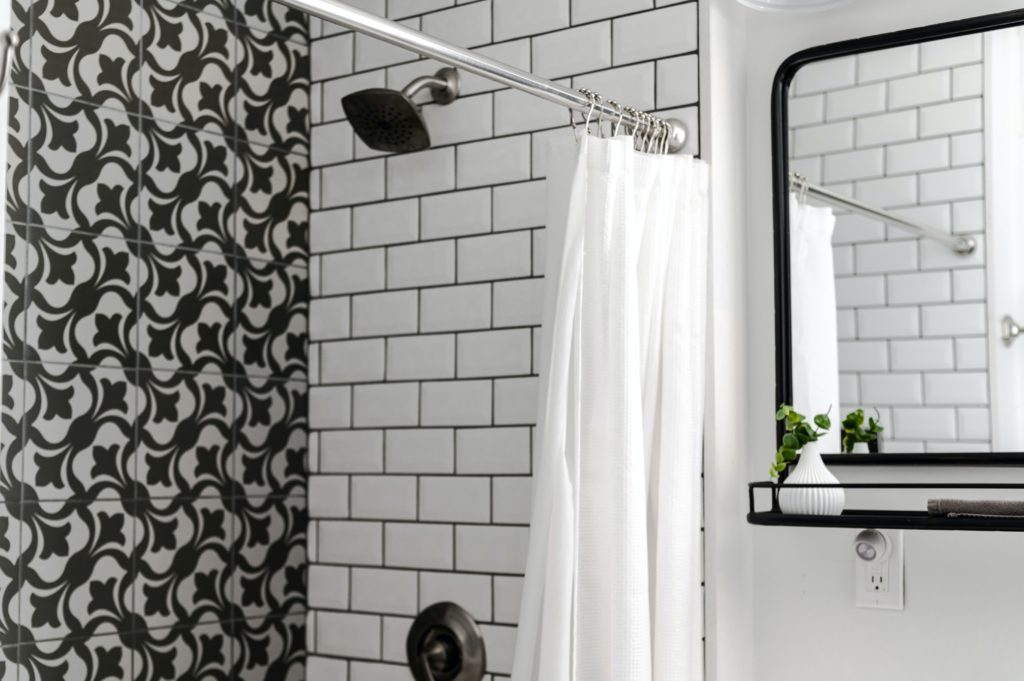 Photograph of shower in black and white tiled bathroom