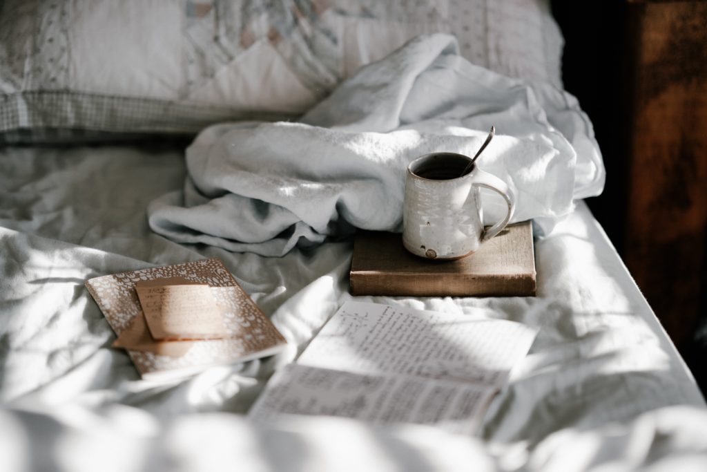 Photograph of books and a mug on a bed