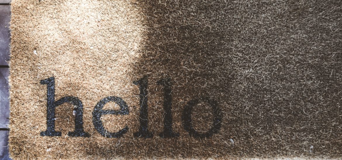 Photograph of a welcome mat with "hello" printed on the bottom left corner
