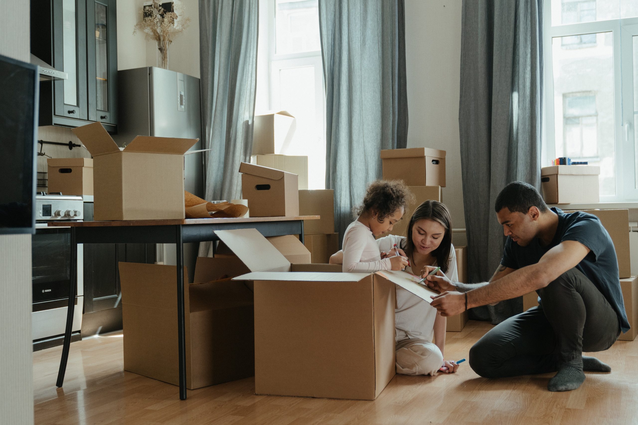 Photo of a family in their new home, surrounded by boxes