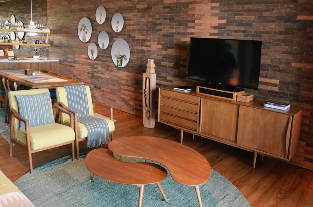 Photograph of a living room with teak chairs, TV cabinet and coffee table