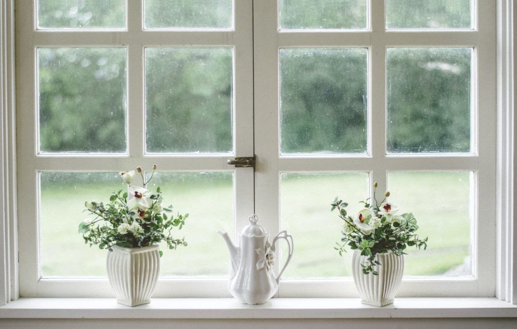 Photograph of window with white frame with vases on the sill