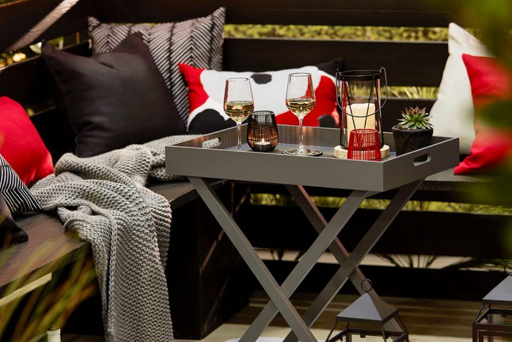 Photo of a patio seating area with small coffee table and cushions