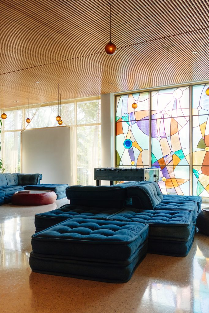 Blue velvet sofa in front of a stain glass window