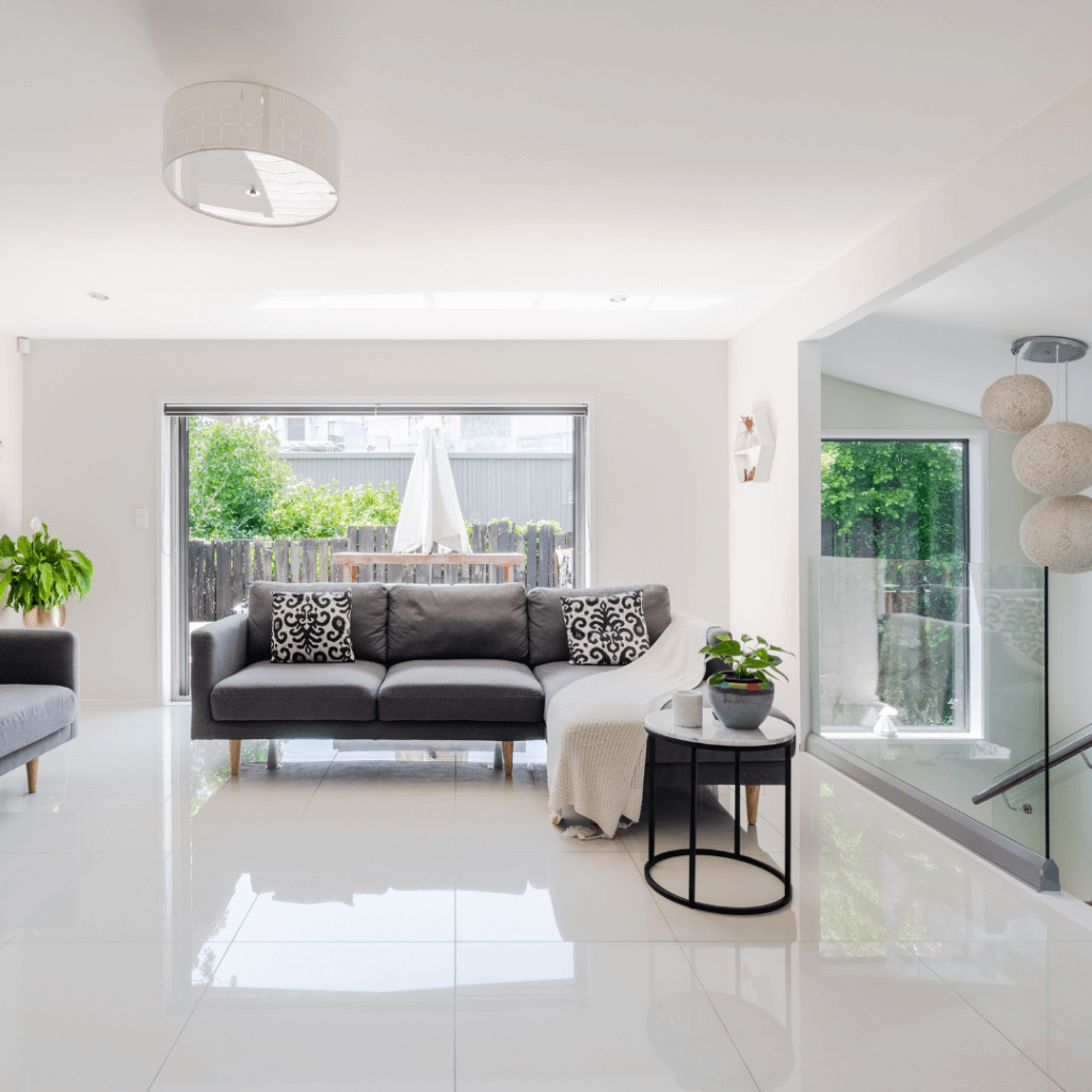 A modern living space with sliding doors leading out into a leafy garden 