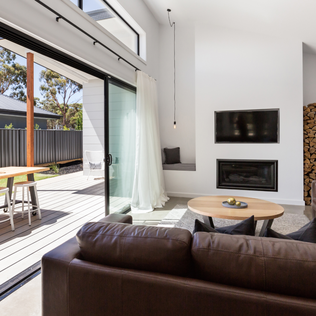 Sliding doors leading from a modern living room to an outdoor decking area